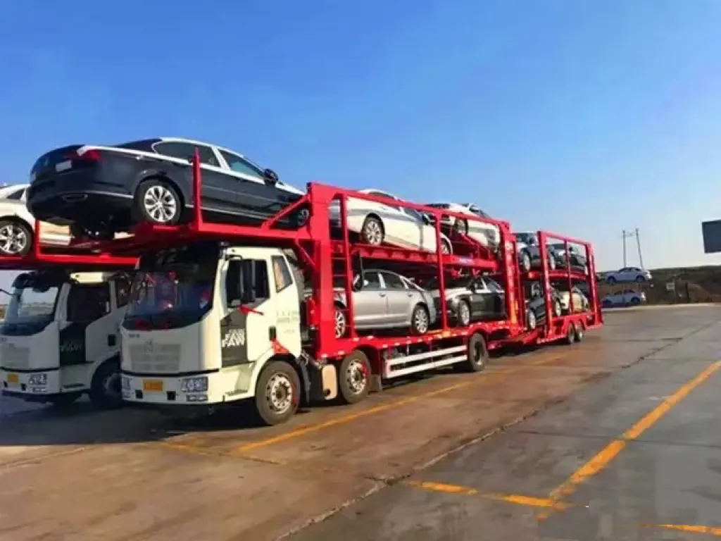 Car-carrier trucks loaded with vehicles for overland export