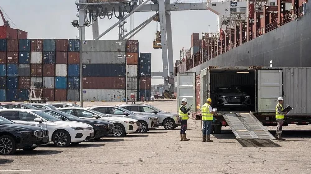 Export vehicles being loaded into a shipping container at a port terminal